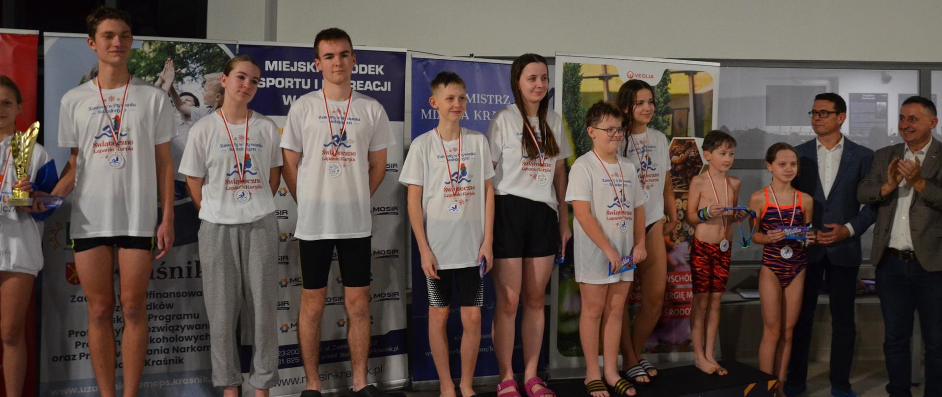 Nagrodzeni zawodnicy w kategorii siostra i brat stojący na podium wraz z medalami i nagrodami. Po prawej ich stronie stoi Przewodniczący Rady Powiatu w Kraśniku Jacek Dubiel, a obok niego Poseł na Sejm Rzeczypospolitej Polskiej Kazimierz Choma.