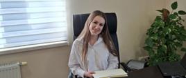 Gabriela Urbaniak w biurze Wójta Gmina Raba Wyżna, W tle na ścianie Godło Gminy oraz Godło Polski