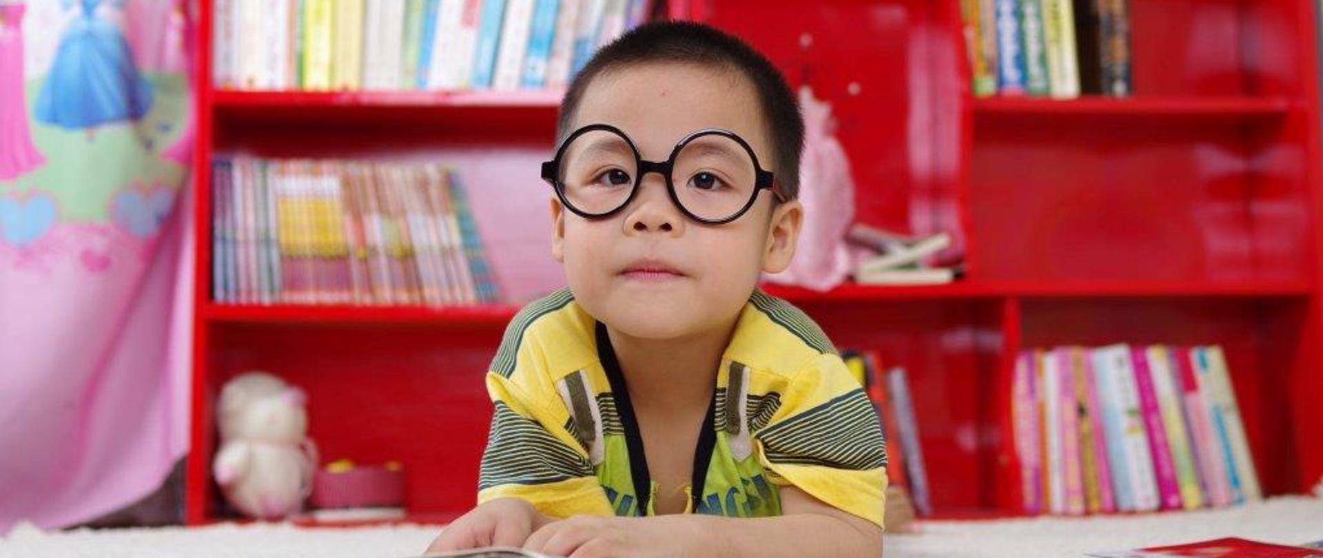 grafika przedstawia czytające dziecko