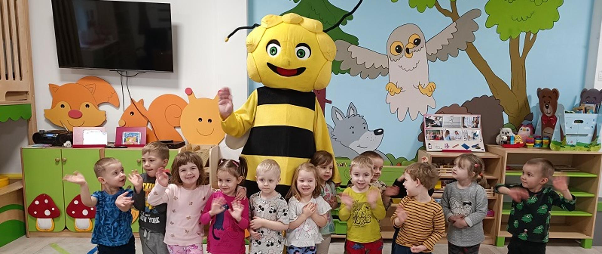 Dzieci pozują do zdjęcia z postacią Pszczółki Mai