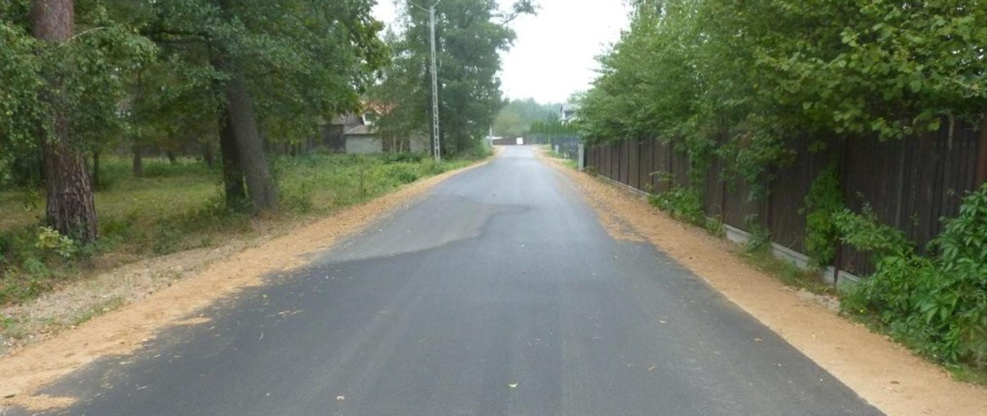 Droga asfaltowa. Pobocza po obu stronach z żółtego piachu