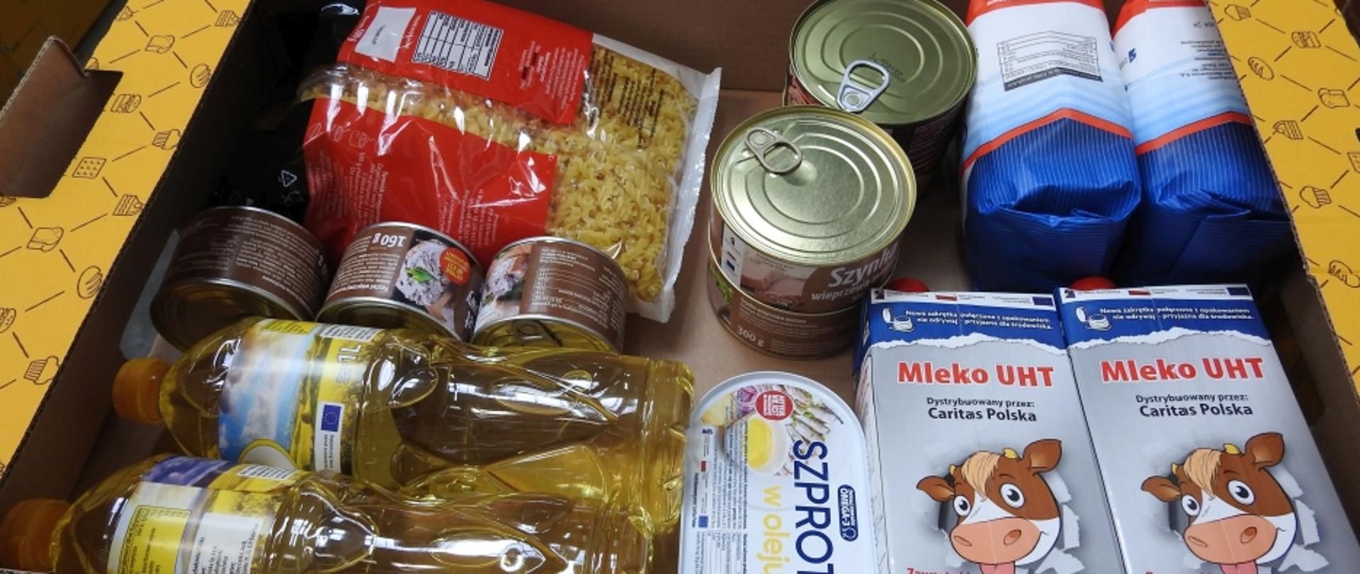 zdjęcie żywności 2x olej, 2x mleko, 2x cukier, konserwy, ryby, makaron wszystko w kartonowym pudełku. 