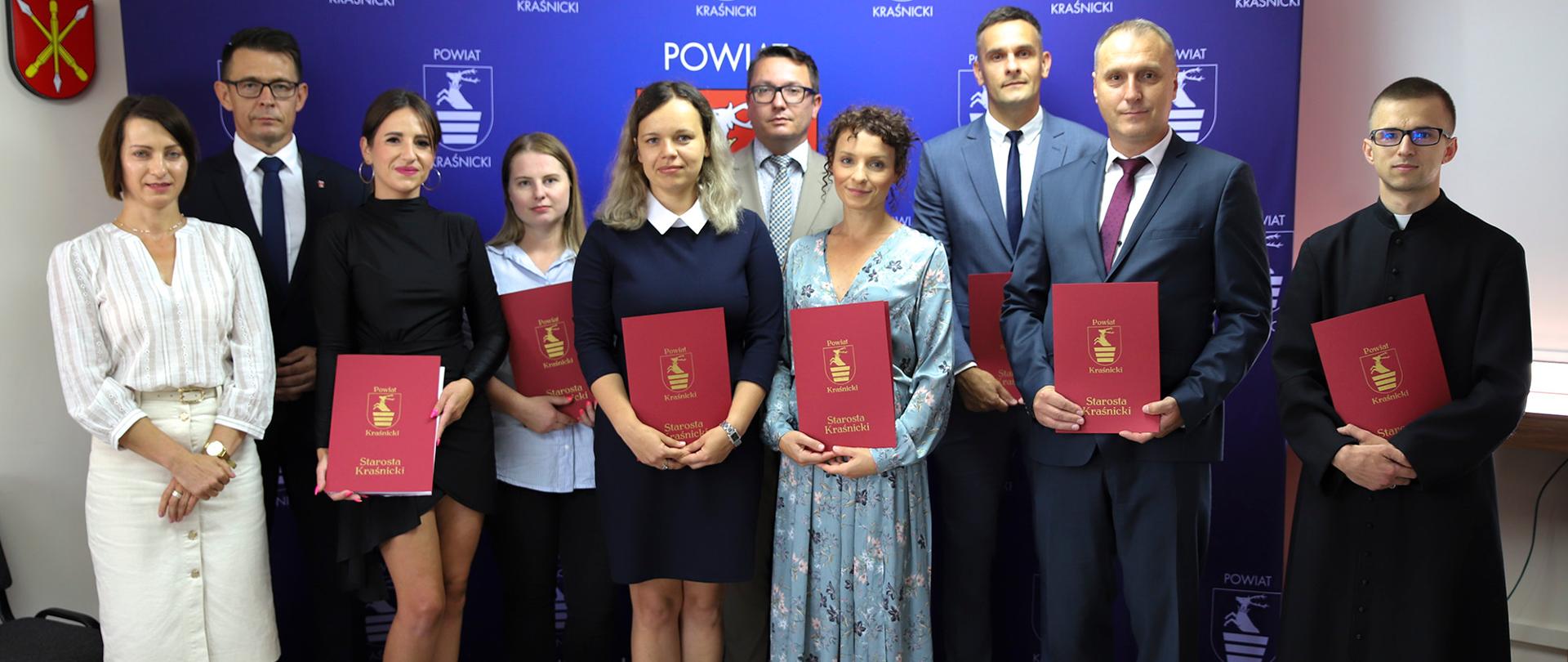 Zdjęcie przedstawia 7 nauczycieli, którzy otrzymali awanse zawodowe od Przewodniczącego Rady Powiatu Jacka Dubiela, Sekretarza Powiatu Kraśnickiego Łukasza Skokowskiego oraz Kierownika Wydziału Edukacji i Sportu Agnieszki Drozd.