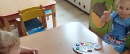 Dzieci siedzą w ławkach, za chwilę zaczniemy malowanie