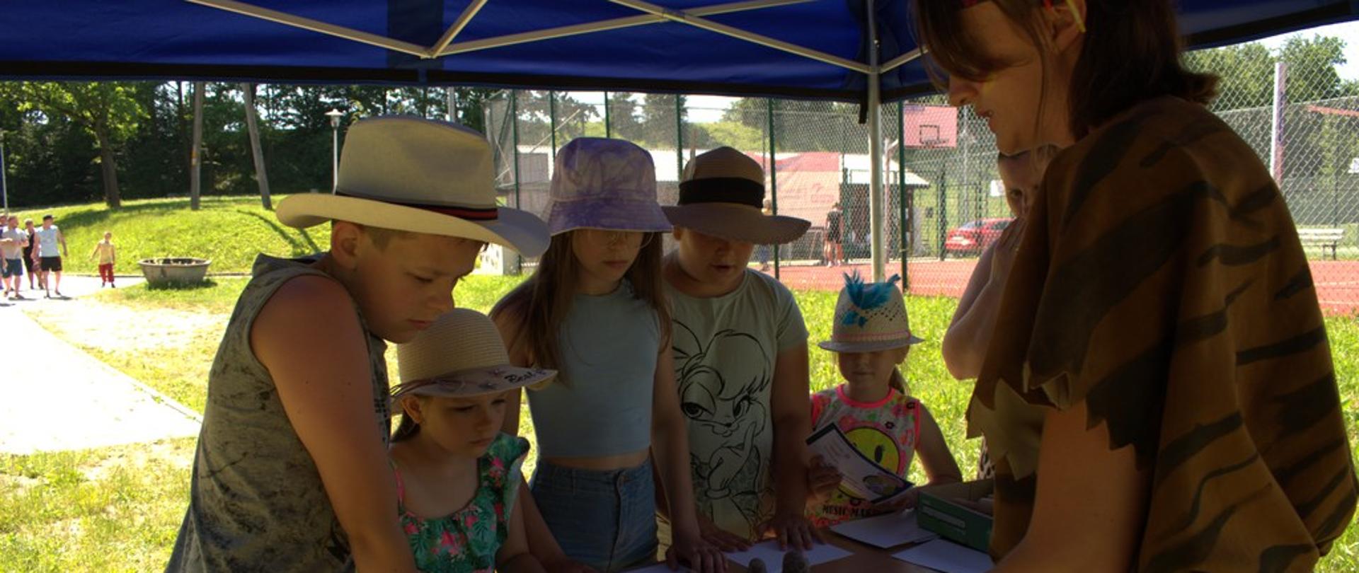 Pięcioro dzieci wykonuje gliniane figurki