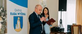Przemowa Przewodniczącego Gminy Raba Wyżna w tle kierownik USC oraz baner z napisem Raba Wyżna i nagłośnienie.
