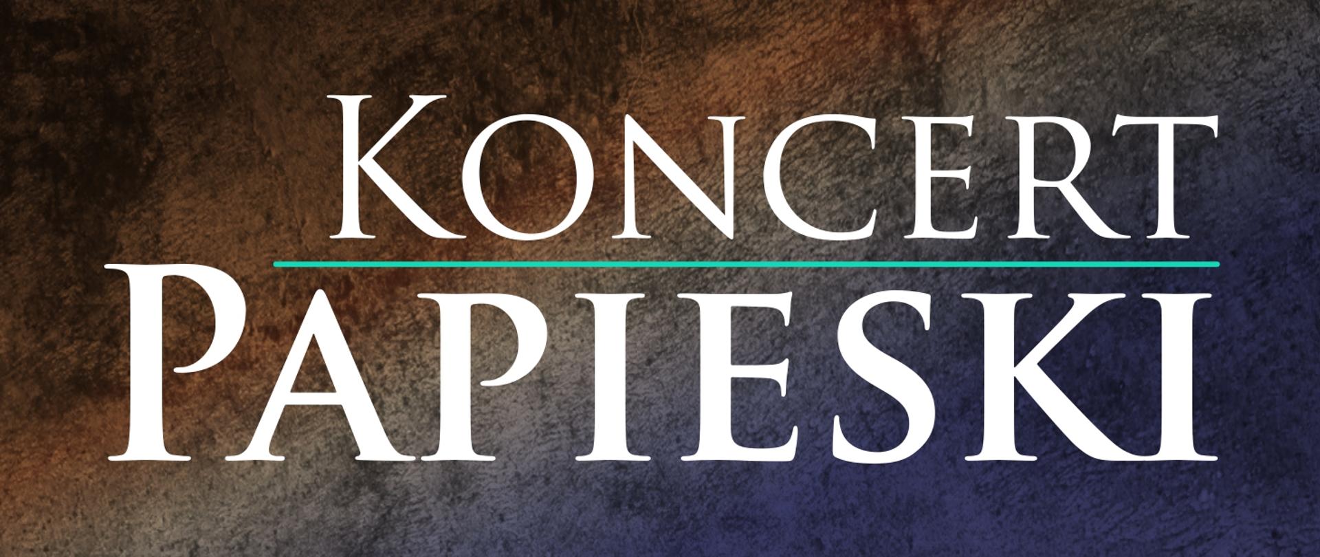 Grafika przedstawia biały napis "Koncert Papieski". Słowa znajdują się jedno nad drugim i są oddzielone zielononiebieską linią. Tło swoim wyglądem imituje kamień, jego barwa przechodzi płynnie od odcieni brązu do granatu.