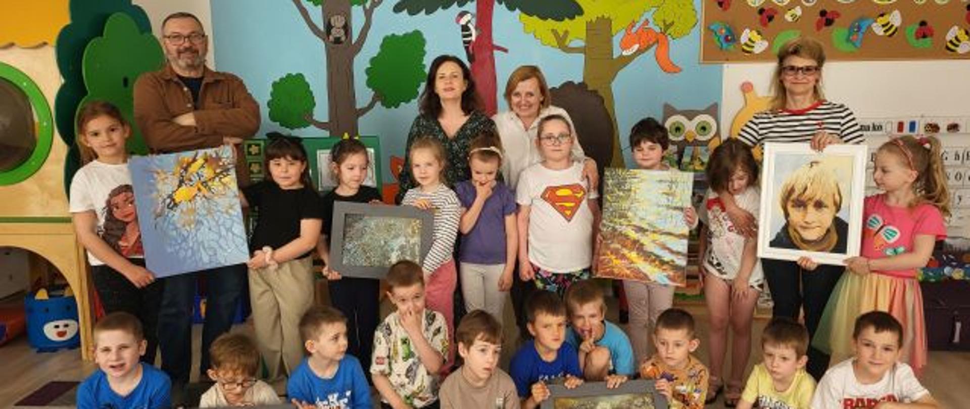 Przedszkolaki wraz z Zbigniewem Budzyńskim i nauczycielkami, pozują do zdjęcia.