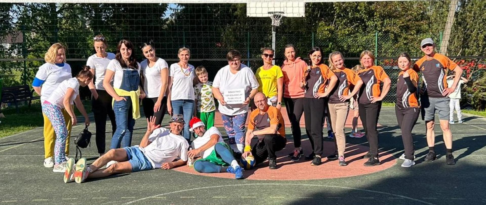 Dwie drużyny sportowe na boisku do siatkówki.