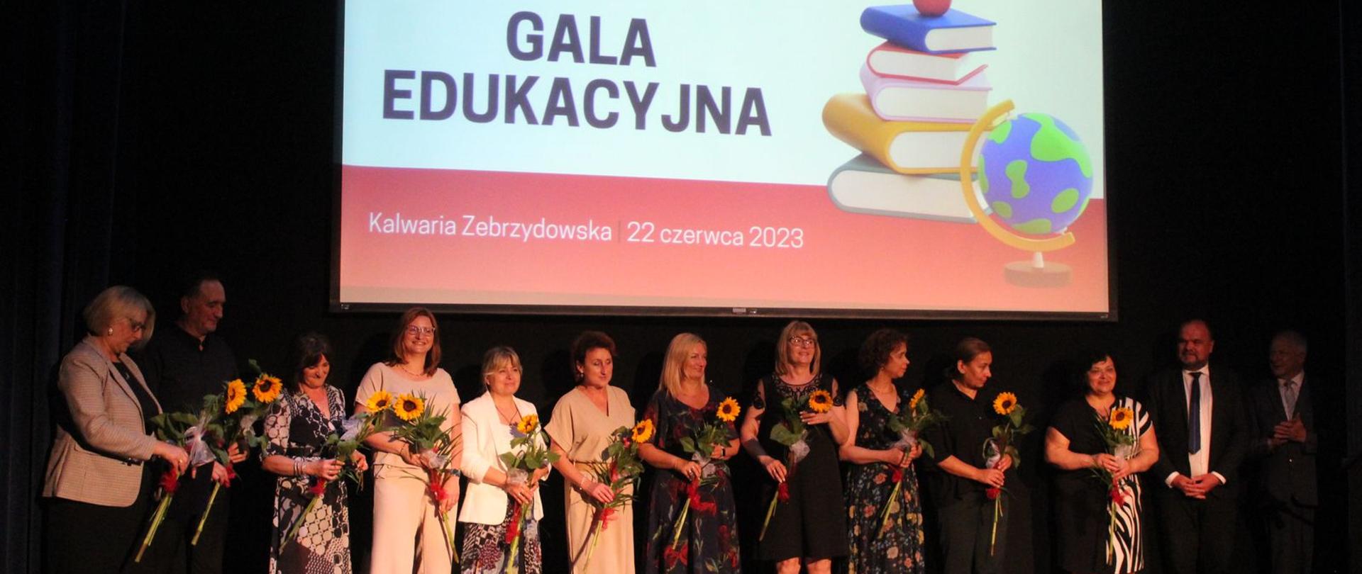 Zdjęcie grupowe, stoją kobiety i mężczyźni. 