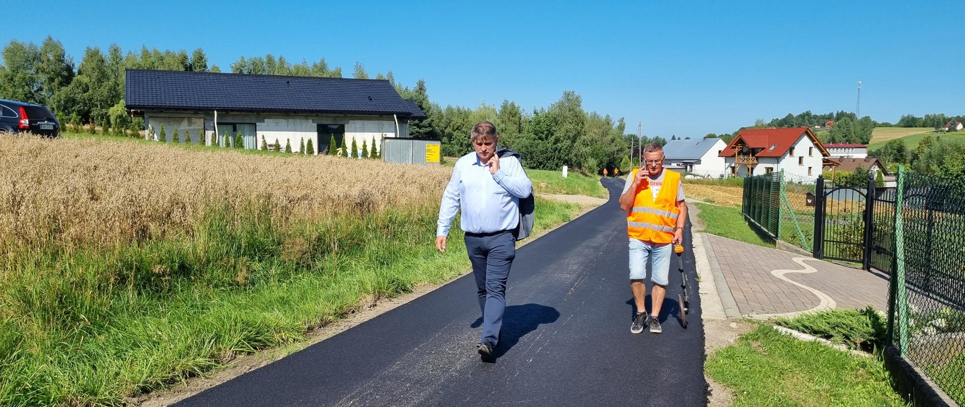 Dwie osoby idą po nowo wyremontowanym odcinku drogi Smolkówka w Barwałdzie Średnim