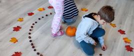 Zabawy z darami jesieni - dzieci układają liście i kasztany