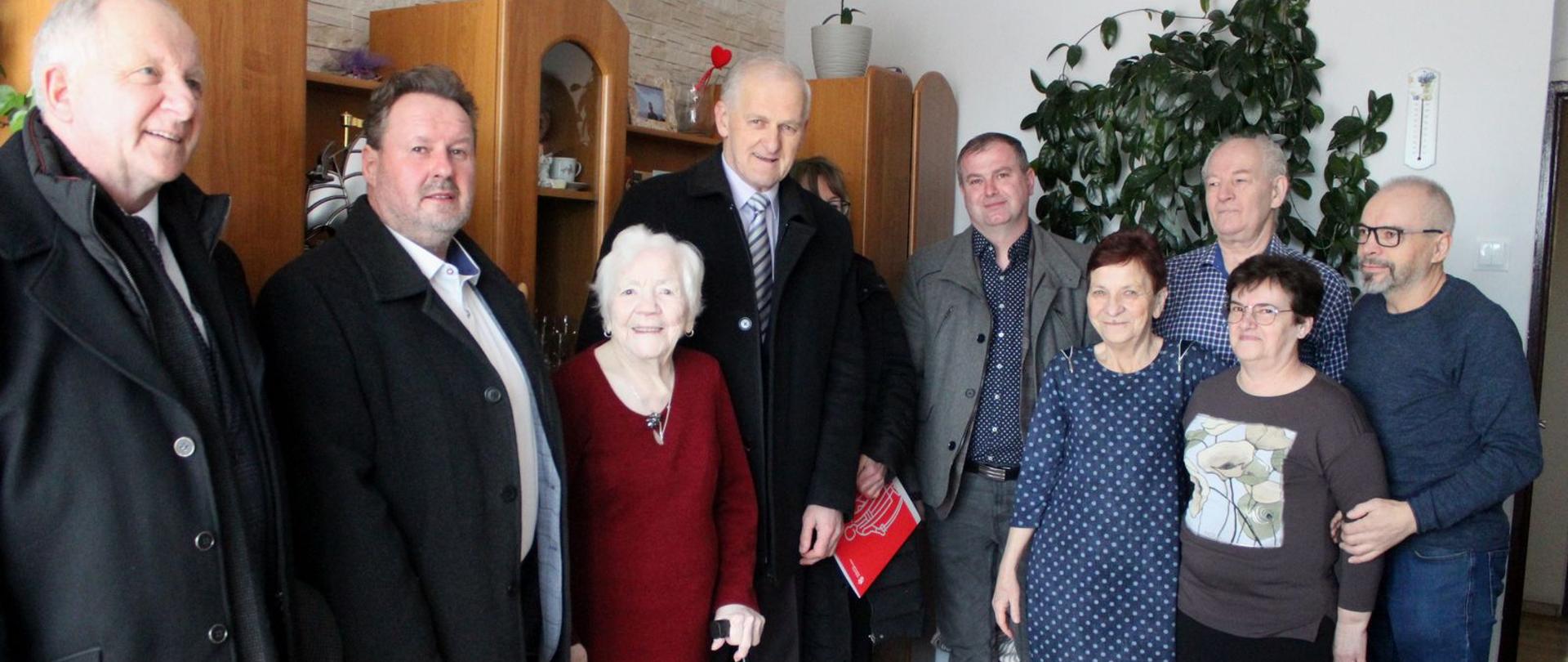 Zdjęcie pamiątkowe z jubilatką - stoi w centralnym miejscu, obok rodzina i władze miasta 