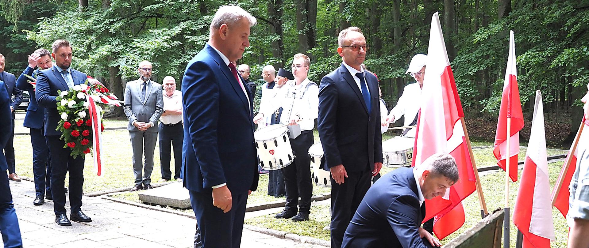 Władze Powiatu Bielskiego składają wiązankę pod krzyżem modlitewnej pamięci w Lesie Pilickim