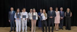 Uczniowie ze szkoły w Skawie nr 1 wspólnie z zastępcom p. dyrektora, panem wójtem, zastępcą wójta, panią Ewą Miśkowiec oraz pracownikiem ZEAS. Wszyscy pozują do zdjęcia na scenie w remizie OSP.