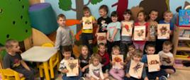 Dzieci pozują do zdjęcia, trzymając w rękach plakaty z symbolami jesieni