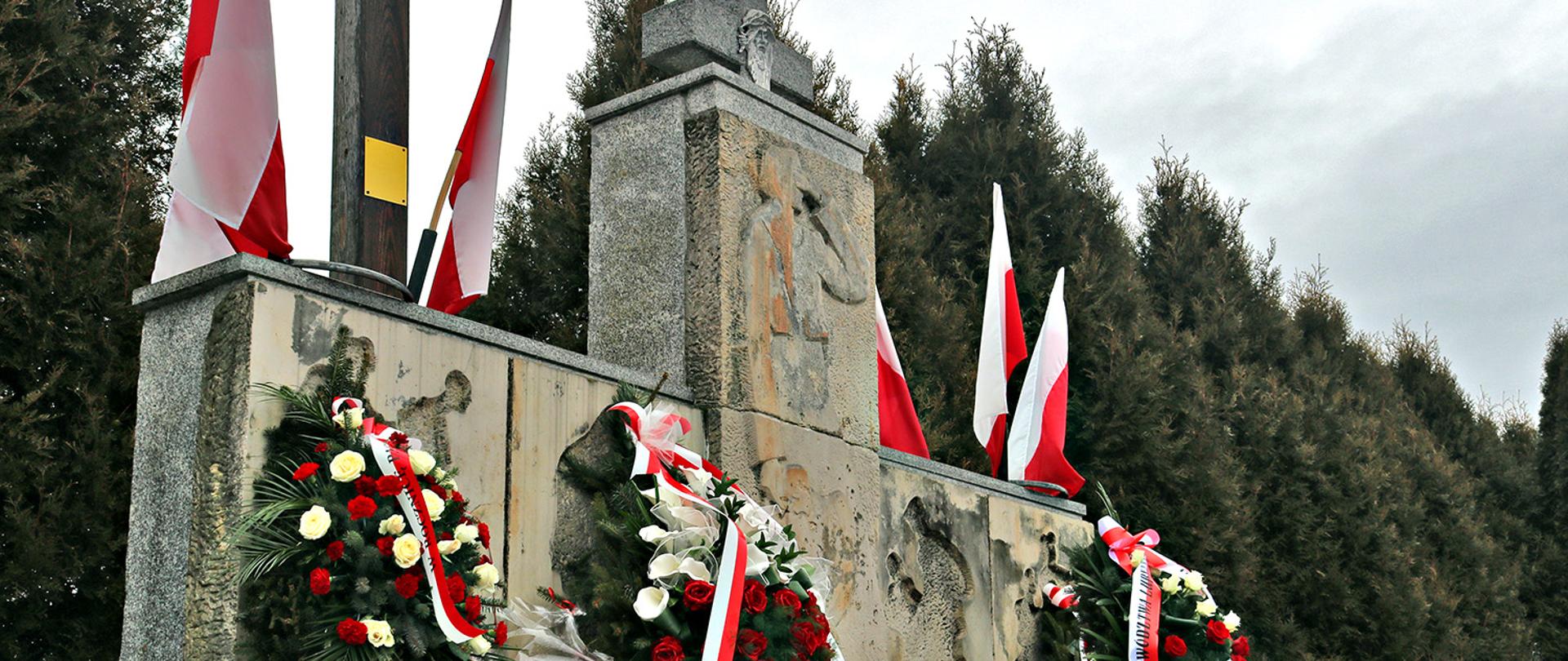 Zdjęcie przedstawia Pomnik Ofiar Pacyfikacji Wsi Borów oraz złożone wieńce delegacji samorządowych podczas oficjalnych uroczystości. 