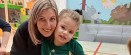 Mama z dzieckiem pozuje do zdjęcia w trakcie zajęć plastycznych
