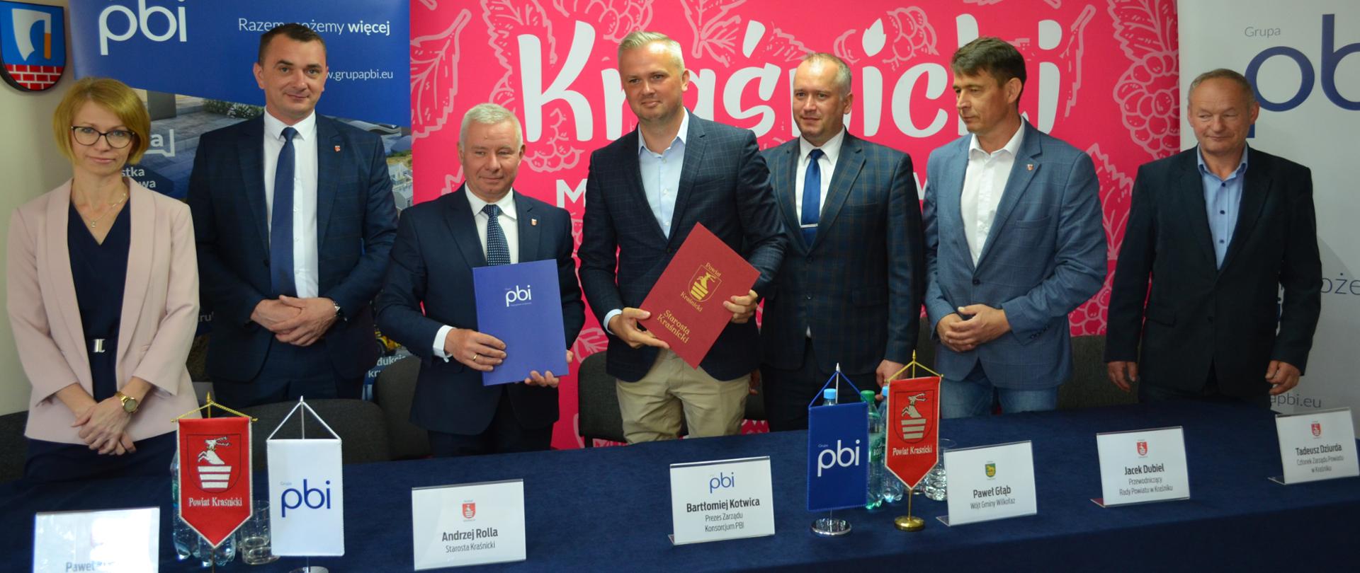 Pamiątkowe zdjęcie po podpisaniu umowy na przebudowę drogi drogi powiatowej nr 2725L przebiegającej przez teren gminy Wilkołaz. Od lewej stoją : Skarbnik Powiatu Iwona Szymańska, Wicestarosta Paweł Kudrel, Starosta Kraśnicki Andrzej Rolla, Prezes Zarządu Konsorcjum PBI Bartłomiej Kotwica, Wójt Gminy Wilkołaz Paweł Głąb, Przewodniczący Rady Powiatu w Kraśniku Jacek Dubiel, Członek Zarządu Powiatu w Kraśniku Tadeusz Dziurda.