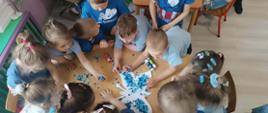 Dzieci kolorują papierowego motyla